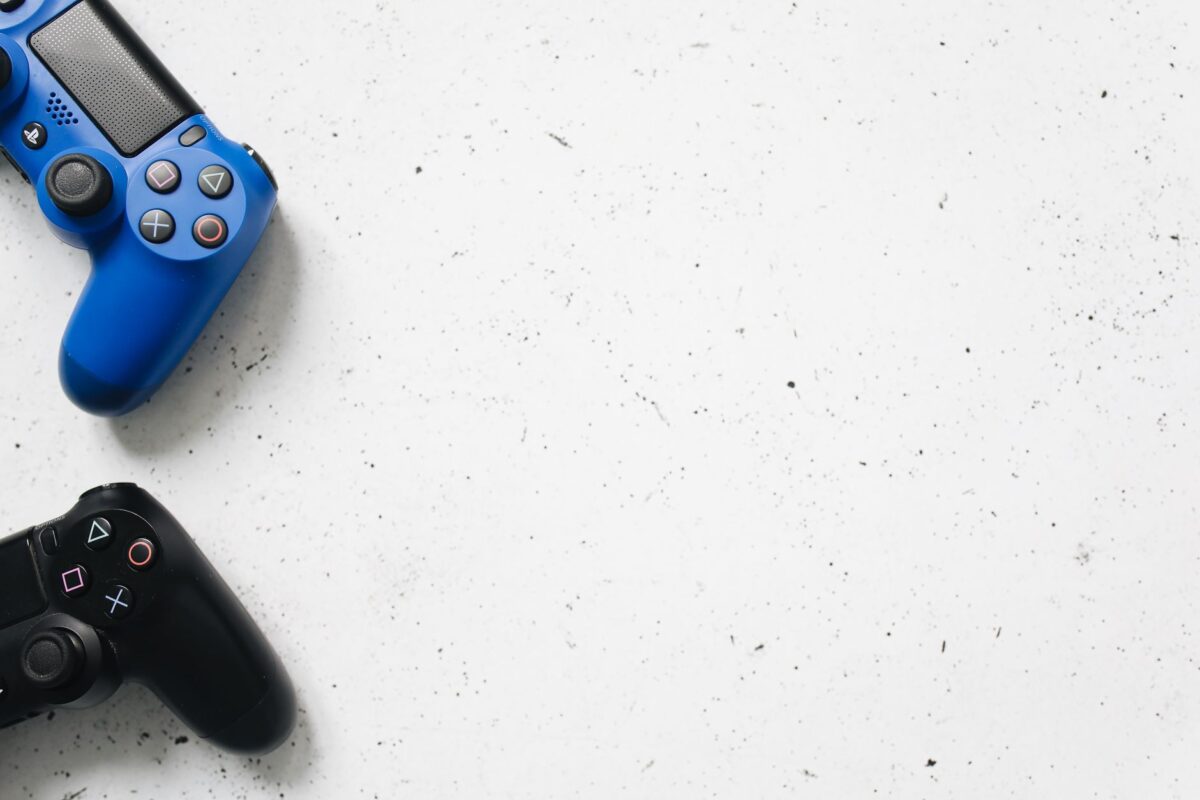 Blue and black PlayStation game controllers on minimal white surface. Perfect for gaming and technology themes.