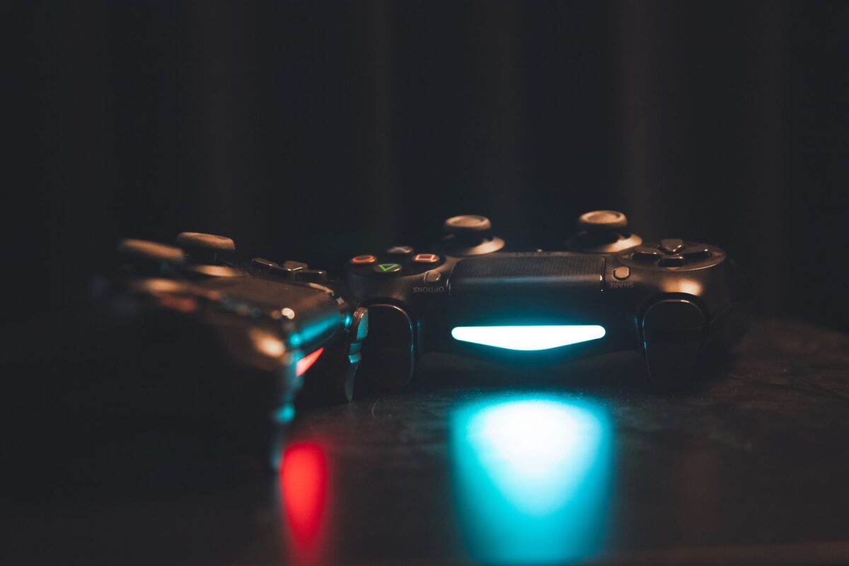 Close-up of glowing gaming controllers on a dark surface, creating a moody ambiance.