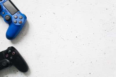 Blue and black PlayStation game controllers on minimal white surface. Perfect for gaming and technology themes.